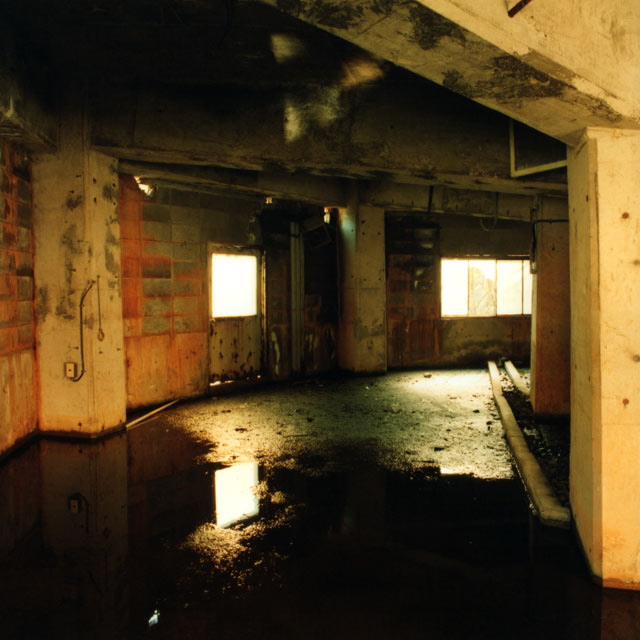 古遠部鉱山 シックナー跡-建屋内部、赤く変色したブロック壁、窓から外の明かりが注ぐ